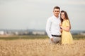 A young couple of lovers woman and man are hugging in nature, in a yellow wheat field. The concept of love, good relationships, Royalty Free Stock Photo