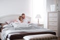 Young couple lying in bed and doing online shopping Royalty Free Stock Photo