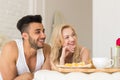 Young Couple Lying In Bed Eat Breakfast Morning With Red Rose Flower, Happy Smile Hispanic Man And Woman Royalty Free Stock Photo