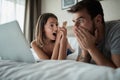 Couple lying in bed at morning and surfing on the net at laptop Royalty Free Stock Photo