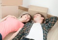 Young couple lying on the floor among cardboard boxes Royalty Free Stock Photo