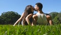 Young couple lying on green grass in park and relaxing. Man and woman sitting on meadow at nature and kissing. Girl and Royalty Free Stock Photo