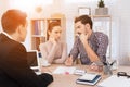 Young couple makes decisions regarding purchase of house sitting in office of real estate agency. Royalty Free Stock Photo