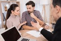 Young couple makes decisions regarding purchase of house sitting in office of real estate agency. Royalty Free Stock Photo