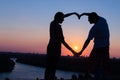 Young couple making heart shape with their hands at sunset Royalty Free Stock Photo