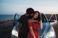 Young Couple Man and Woman Hugging and Kissing Near Their SUV Car on the Seaside After Sunset, Lovers Enjoying Moment Royalty Free Stock Photo