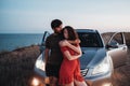 Young Couple Man and Woman Hugging Near Their SUV Car on the Seaside After Sunset, Lovers Enjoying Moment Together Royalty Free Stock Photo