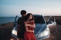 Young Couple Man and Woman Hugging Near Their SUV Car on the Seaside After Sunset, Lovers Enjoying Moment Together Royalty Free Stock Photo
