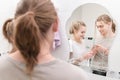 A young couple man and woman with long hair in the morning in front of a bathroom mirror squeeze toothpaste themselves Royalty Free Stock Photo