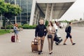 Young couple, man and woman near the airport with a suitcase. Happy couple traveling. Young people returning from a trip