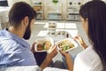 Young couple man and woman office workers sitting and enjoying healthy boxed food order