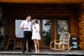 Young couple - man and woman relaxing on terrace of wooden house in mountains. Romantic morning of two lovers. Couple drinking hot Royalty Free Stock Photo