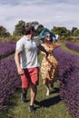 A young couple, a man and a woman, are running on a blooming lavender field Royalty Free Stock Photo