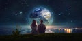 young couple man and woman sit on rock at night sea watching starry sky and big moon on horizon mediterranean city Royalty Free Stock Photo