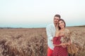 Young couple man and woman in summer wheat field, hugging and relaxing in fresh air. The concept of love joy and care Royalty Free Stock Photo