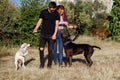 Young couple man and woman walk with their dogs in the park