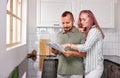 Young couple managing finances, reviewing their bank accounts holding paper document Royalty Free Stock Photo