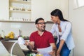 Couple managing finances, reviewing their bank accounts using laptop computer at modern kitchen Royalty Free Stock Photo