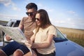 Couple with map choosing the best road for road trip