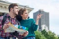 Young couple with a map in the city. Happy tourists sightseeing city with map Royalty Free Stock Photo