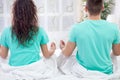 Young couple meditating together in their bedroom Royalty Free Stock Photo