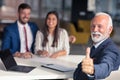 Young couple meeting financial advisor for home investment. Advisor showing thumbs up. Royalty Free Stock Photo