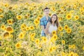 Young couple man and woman girlfriend and boyfriend wife and husband standing in sunflowers field. Love, romance, togetherness,