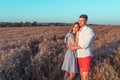 Young couple, man and woman in summer in wheat field, hugging and relaxing in fresh air. The concept of love is joy and Royalty Free Stock Photo