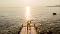 Young couple men and women on a wooden pier watching sunset during vacation in Turkey Royalty Free Stock Photo