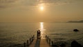 Young couple men and women on a wooden pier watching sunset during vacation in Turkey Royalty Free Stock Photo