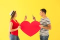 Young couple with mobile phones and big paper heart on color background Royalty Free Stock Photo