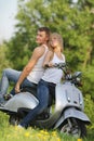 Young couple on motorbike / scooter on nature Royalty Free Stock Photo