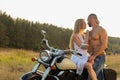 Young couple on a motorcycle in the field