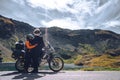 Young couple of motorcycle travelers in the autumn mountains of Romania. Moto tourism and moto travellers lifestyle while