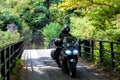 Young couple of motorcyclists riding on forest road in Zagorochoria, Greece