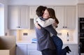 Young Couple Moving Into New Home Hugging As They Unpack Boxes In Kitchen Together Royalty Free Stock Photo