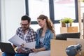 Young couple moving in new home. Sitting and relaxing after unpacking. Looking something on laptop Royalty Free Stock Photo