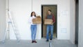 A young attractive couple moving into a new home. A couple is standing on the doorstep holding boxes in their hands. Royalty Free Stock Photo