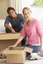 Young Couple Moving Into New Home Unpacking Boxes Royalty Free Stock Photo