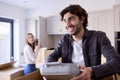 Young Couple Moving Into New Home Unpacking Boxes In Kitchen Together Royalty Free Stock Photo