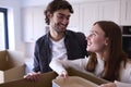 Young Couple Moving Into New Home Unpacking Boxes In Kitchen Together Royalty Free Stock Photo