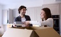 Young Couple Moving Into New Home Unpacking Boxes In Kitchen Together Royalty Free Stock Photo