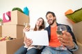 Young couple moving in new property house - Happy lovers having fun shopping online with digital tablet in new home Royalty Free Stock Photo