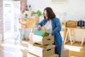 Young couple moving to new apartment, beautiful woman moving cardboard boxes and smiling happy