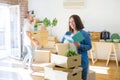 Young couple moving to new apartment, beautiful woman moving cardboard boxes and smiling happy