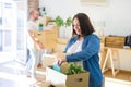 Young couple moving to new apartment, beautiful woman moving cardboard boxes and smiling happy