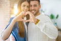 Young couple moving to a new home, hugging in love showing keys of new apartment smiling very happy Royalty Free Stock Photo