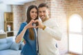 Young couple moving to a new home, hugging in love showing keys of new apartment smiling very happy Royalty Free Stock Photo