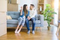 Young couple moving to a new home, hugging in love showing keys of new apartment smiling very happy Royalty Free Stock Photo