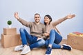 Young couple moving to a new home looking at the camera smiling with open arms for hug Royalty Free Stock Photo